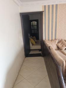 a hallway of a room with a couch and a stairway at We'llcome home in Temara