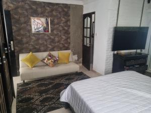 a living room with a couch and a television at We'llcome home in Temara