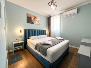 une chambre avec un lit avec une tête de lit bleue dans l'établissement Tier Hotel, à Tirana