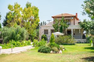 a house with a garden in front of it at Agios Mamas Resort in Nea Potidaea