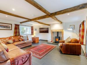 a living room with leather furniture and a fireplace at 3 Bed in Caldbeck 86087 in Caldbeck