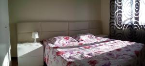 a bedroom with a bed with a flowered blanket at Blue Ocean in Póvoa de Varzim