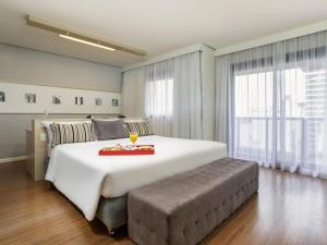 a bedroom with a large bed and a large window at Mercure Sao Paulo Pamplona in Sao Paulo +102 photos