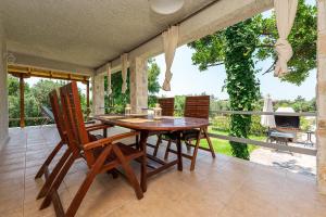 a dining room with a table and chairs on a balcony at Agios Mamas Resort in Nea Potidaea