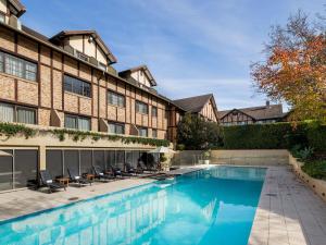 a swimming pool in front of a building at Peppers The Hills Lodge in Castle Hill