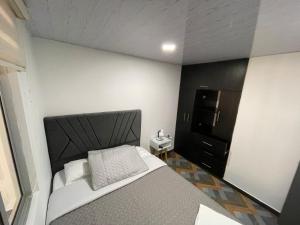 a small bedroom with a bed and a refrigerator at Apartamento independiente en casa familiar Fusagasugá in Fusagasuga +32 photos