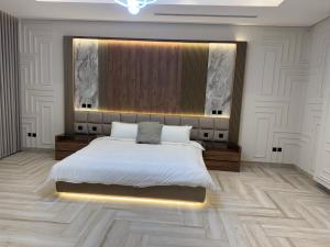 a bedroom with a large bed with a lighted headboard at Villa, 6BR with swimming pool next to Stars avenue in Jeddah +45 photos
