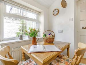 une table de salle à manger avec un panier de fleurs et une fenêtre dans l'établissement 3 Bed in Danby 46583, à Moorsholm 19 autres photos