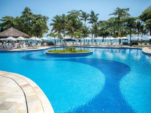 グアルジャにあるHotel Jequitimar Guaruja Resort & Spa by Accor - Ex Sofitelのリゾート内の青い水を使用した大型プール