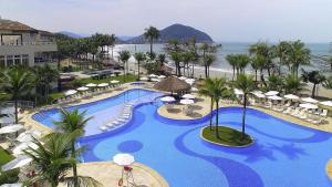 an aerial view of a resort pool with chairs and umbrellas at Hotel Jequitimar Guaruja Resort & Spa by Accor - Ex Sofitel in Guarujá