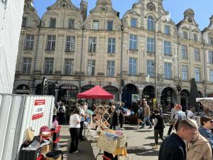 a group of people standing in front of a large building at Joli appartement au pied du beffroi in Arras