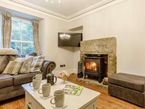 a living room with a couch and a fireplace at 4 Bed in Cromford 82198 in Cromford