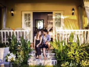 フーコックにあるLa Veranda Resort Phu Quoc - MGalleryの家の玄関に座る男女