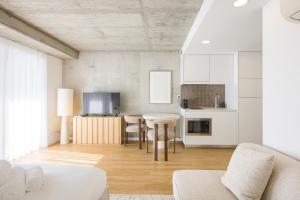 a kitchen and living room with a table and chairs at * Blanc Studio Aveiro * in Aveiro