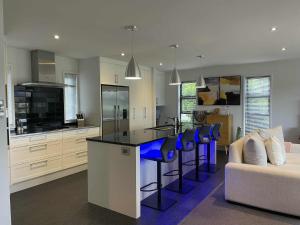 a kitchen with a island with blue bar stools at Great getaway in Picton