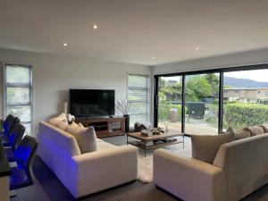 a living room with couches and a flat screen tv at Great getaway in Picton