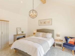 a bedroom with a bed and a blue chair at 3 Bed in Porthtowan 88102 in Redruth