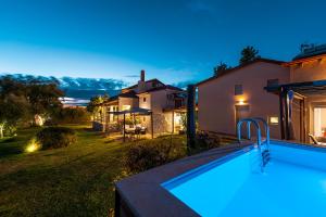 a backyard with a swimming pool and a house at Agios Mamas Resort in Nea Potidaea