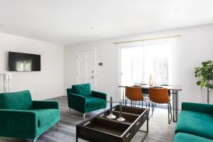 a living room with green chairs and a table at Relax in Spacious 3BR Apt Sleeps 8 and Parking in Glendale