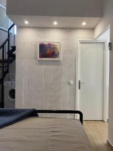 a bedroom with a bed and a painting on the wall at KALLISTO's Apartment , 30m from the sea , Nea Plagia in Nea Plagia