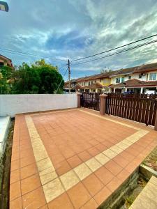 a brick patio in front of a wooden fence at Homestay Harmony in Melaka +2 photos