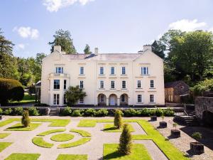 an exterior view of a large white house with a garden at 4 Bed in Cray 82529 in Cray