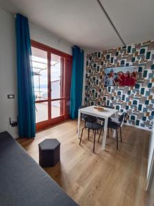 a room with a table and chairs and a window at MAISON PALMENTELLo 3 in Forza dʼAgro