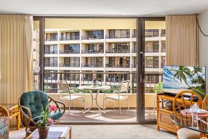 sala de estar con balcón con mesa y sillas en Sugar Beach 304, en Kihei