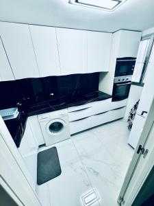 a kitchen with white cabinets and a washing machine at EliMar-Torrevieja Beach in Torrevieja +14 photos