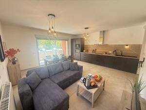 a living room with a couch and a kitchen at Le Moulin Balcon Proche Centre Calme in Saint-Jean-de-Maurienne