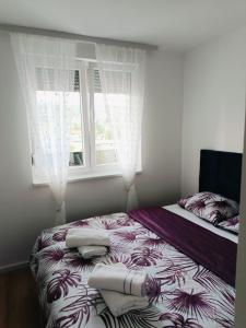 a bed in a room with a window with towels on it at Fort view in Doboj