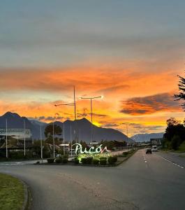 a road with a sunset in the background at Volcán View Pucón in Pucón