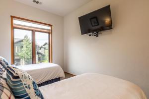 a room with two beds and a tv on the wall at Snowcreek V 770 in Mammoth Lakes