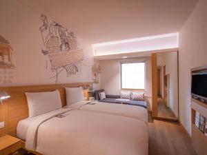 a hotel room with a large bed and a television at ibis Jaipur City Centre - An Accor Brand in Jaipur +53 photos