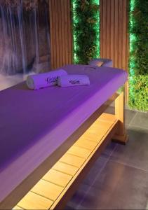 a bed with two purple pillows on top of it at Aqua Lux apartmani in Vršac +62 photos