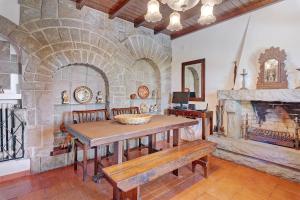 a dining room with a table and a stone fireplace at 30min from beach Seclueded House with pool Quinta La Rabide in Azeitao