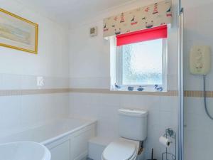 a bathroom with a toilet and a sink and a window at 3 bed in Freshwater East FB100 in Hodgeston +19 photos