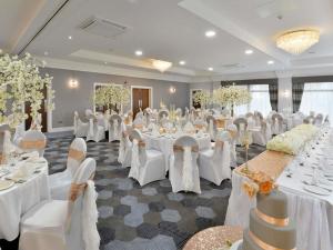 a banquet hall with white tables and white chairs at Mercure Manchester Norton Grange Hotel & Spa in Rochdale +181 photos