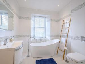 a bathroom with a tub and a sink and a toilet at 4 bed property in Ardentinny 79529 in Ardentinny +50 photos