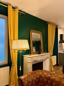 a living room with a mirror and a couch at La Suite Shelby Brive in Brive-la-Gaillarde
