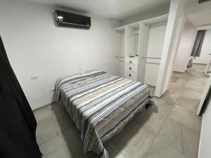 Un dormitorio con una cama en una habitación blanca. en Casa bbb, en Chihuahua