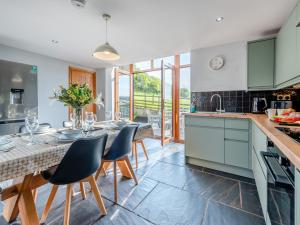 a kitchen with green cabinets and a table with chairs at 4 Bed in Kidwelly CWRTY in Kidwelly