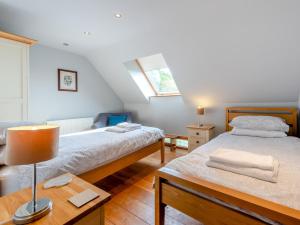 a bedroom with two beds and a table with a lamp at 4 Bed in Kidwelly CWRTY in Kidwelly