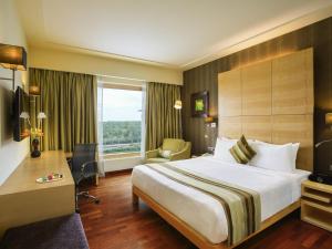 a hotel room with a large bed and a window at Novotel Hyderabad Airport in Hyderabad +197 photos