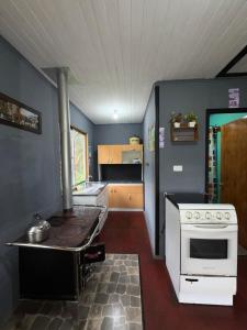 a kitchen with a stove and a stove top oven at Cabaña Curacautín, IX Región in Curacautín