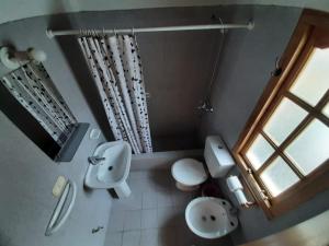 a bathroom with a sink and a toilet and a window at Puma Hostel in San Martín de los Andes +18 photos