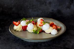 a plate of food with strawberries and whipped cream at Holiday Inn Derby Riverlights by IHG in Derby +34 photos