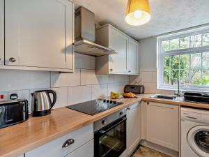 a kitchen with white cabinets and a stove top oven at 2 Bed in Llangynidr BN052 in Llangynidr +22 photos