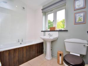 a bathroom with a sink and a tub and a toilet at 4 Bed in Llanidloes 51651 in Llandinam +18 photos