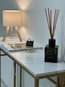 a table with a lamp and a book on it at Central Apartment in Matera